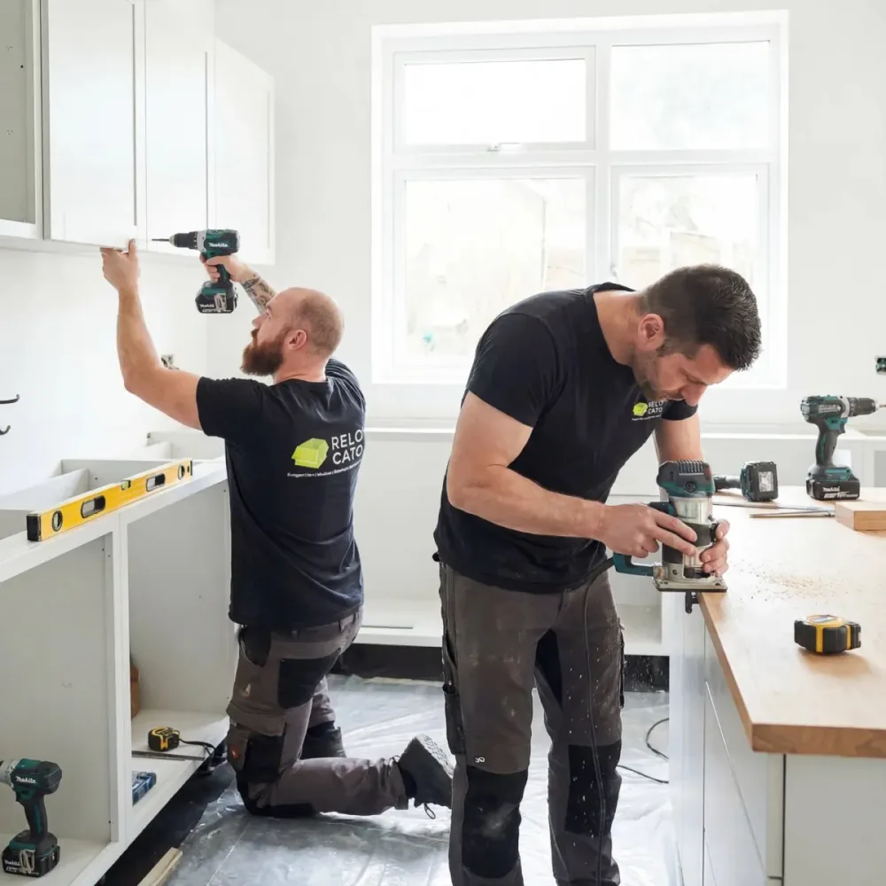 Zwei Relocato-Mitarbeiter montieren eine Küche mit Akkuwerkzeug
